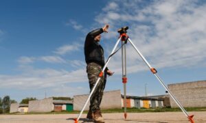 Land surveyor using tripod equipment during a topographic survey in Kansas City subdivision site