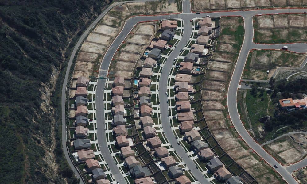 Aerial view of a neighborhood with houses and cleared lots highlighting property line survey disputes and urban development