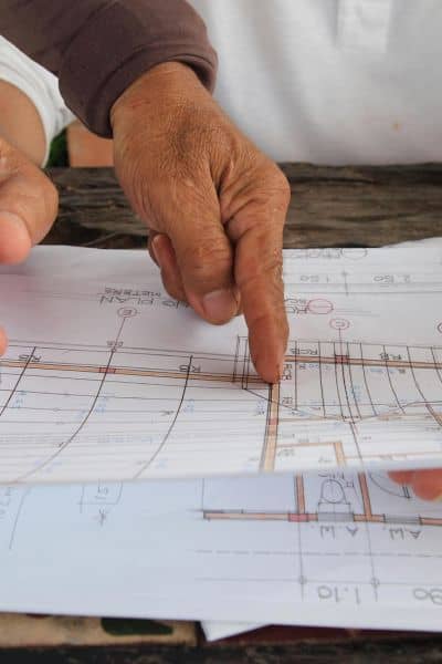Hands reviewing plats and recorder documents for an ALTA Land Title Survey
