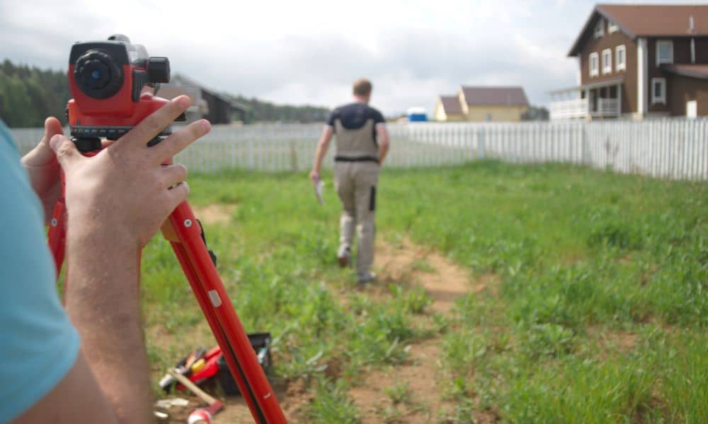 Surveyor performing a boundary survey on residential property after ground movement
