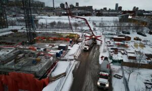 Aerial view of construction site showing trucks and heavy equipment preparing land development that requires an alta title survey