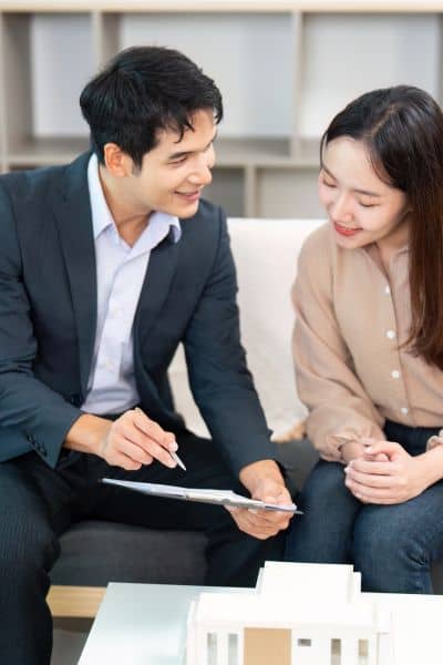 Clients discussing boundary survey results - ALTA SURVEY Missouri Real estate agent reviewing boundary survey results with clients to prevent closing delays