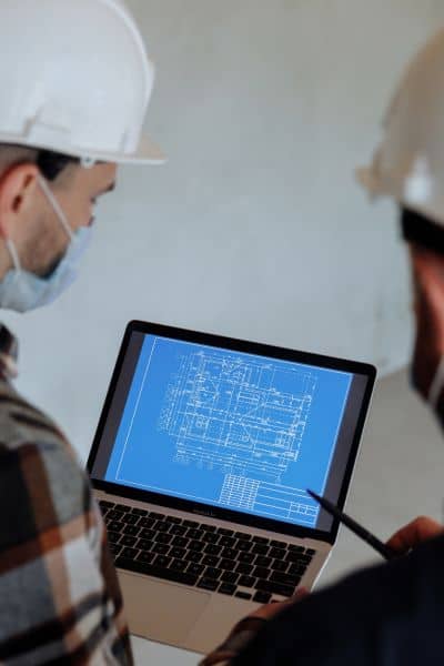 Licensed land surveyor reviewing digital blueprints - ALTA SURVEY Missouri Licensed land surveyor reviewing digital as-built blueprints on a laptop to ensure construction accuracy and compliance