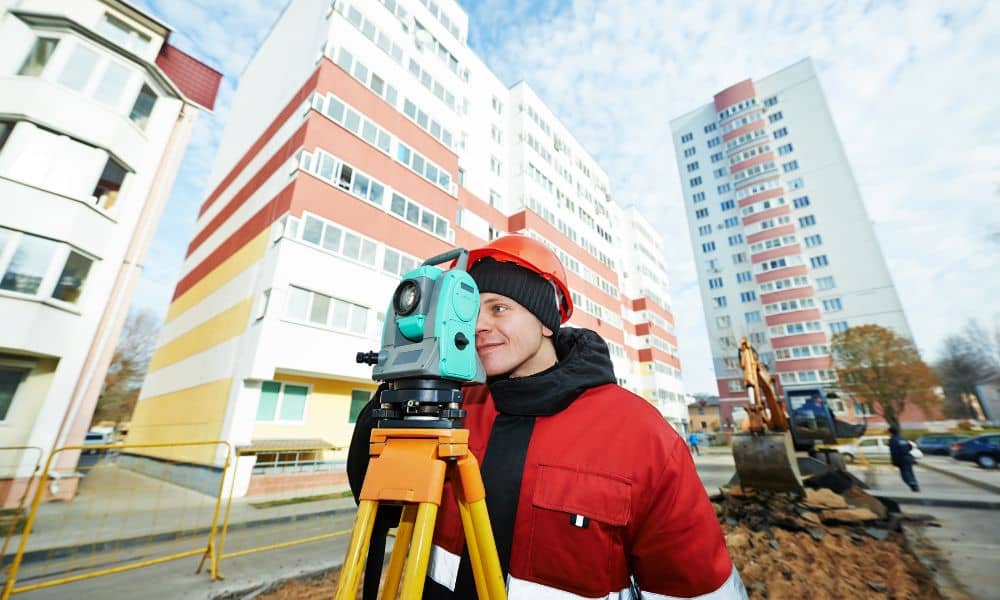 Licensed land surveyor urban construction site - ALTA SURVEY Missouri Licensed land surveyor using a total station at an urban construction site to ensure precise building alignment