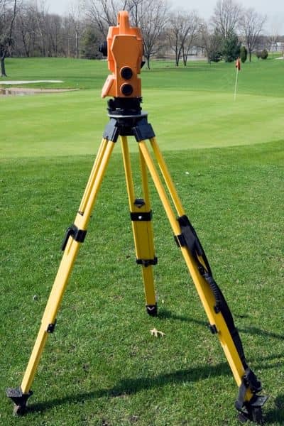 A total station set up on open ground, showing how survey equipment collects elevation details during a topo survey for early site planning