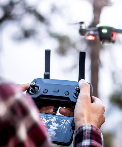 A drone operator controls a drone during an aerial surveying task at a development site