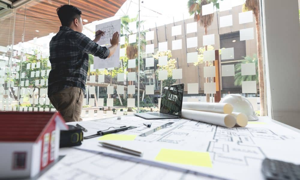 Architect reviewing site plans and drawings in an office while preparing documents for permit approval
