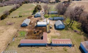 Perc test rural workshop property - ALTA SURVEY Missouri Aerial view of a rural property with barns, workshops, open fields, and existing buildings where a perc test may be planned